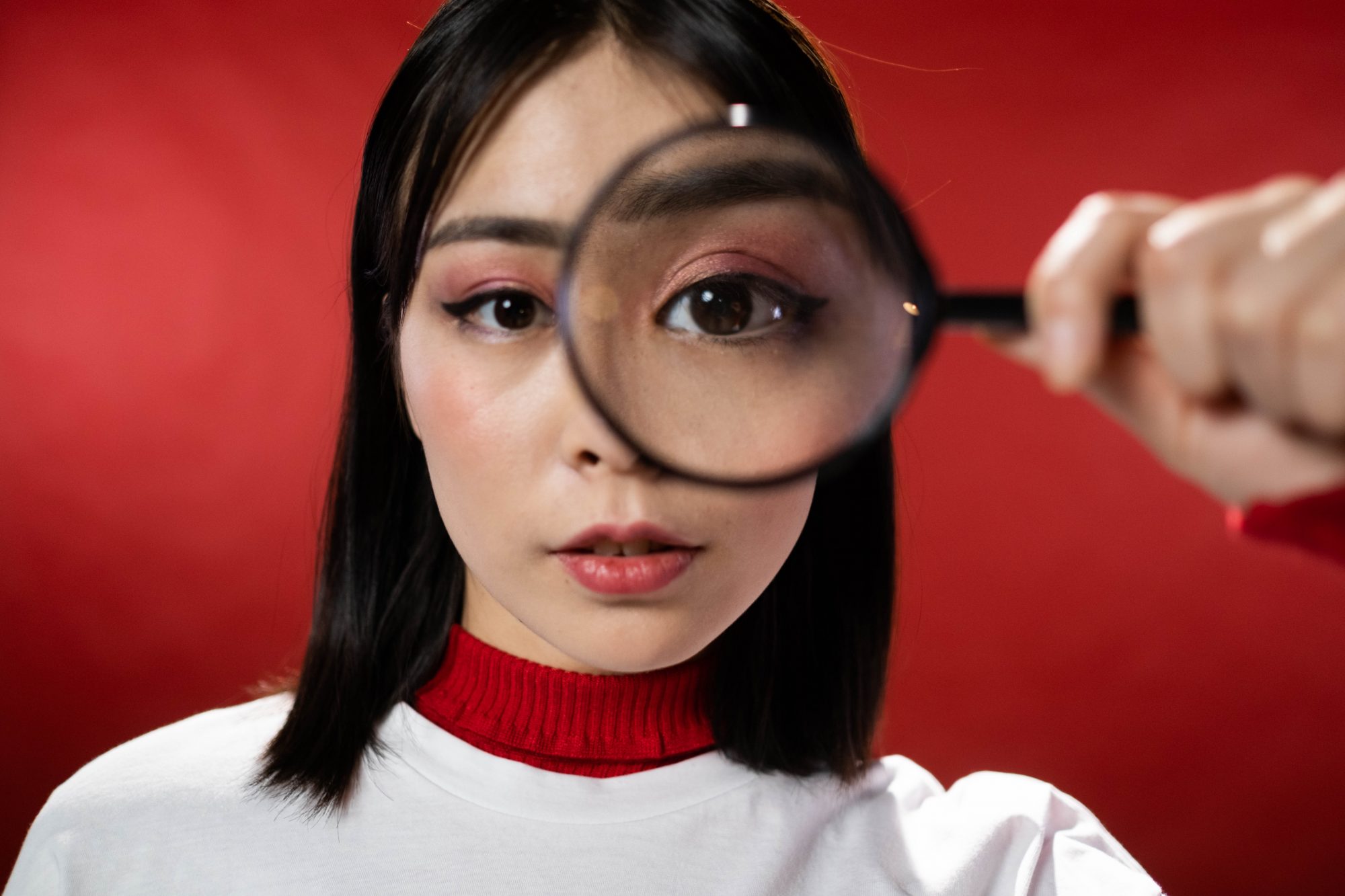 woman looking through magnifying glass